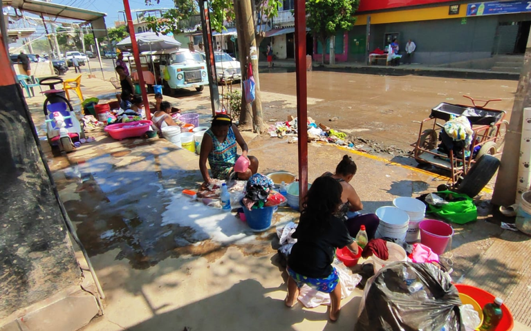 Ante falta de servicios por Otis, habitantes de Acapulco lavan su ropa en las calles